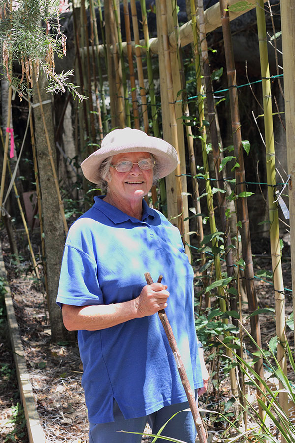 Niki Hill stands proudly in front of a trellis that supports 20 Richmond Birdwing Vines.